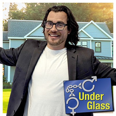 Smiling man with dark hair and glasses, standing in front of a house with the Under Glass logo in the foreground